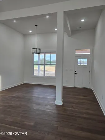 an empty room with wooden floor and window