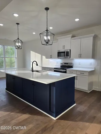 a kitchen with kitchen island granite countertop a sink stainless steel appliances and white cabinets