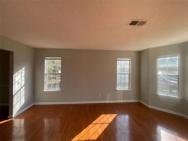 a view of a livingroom with wooden floor and a window