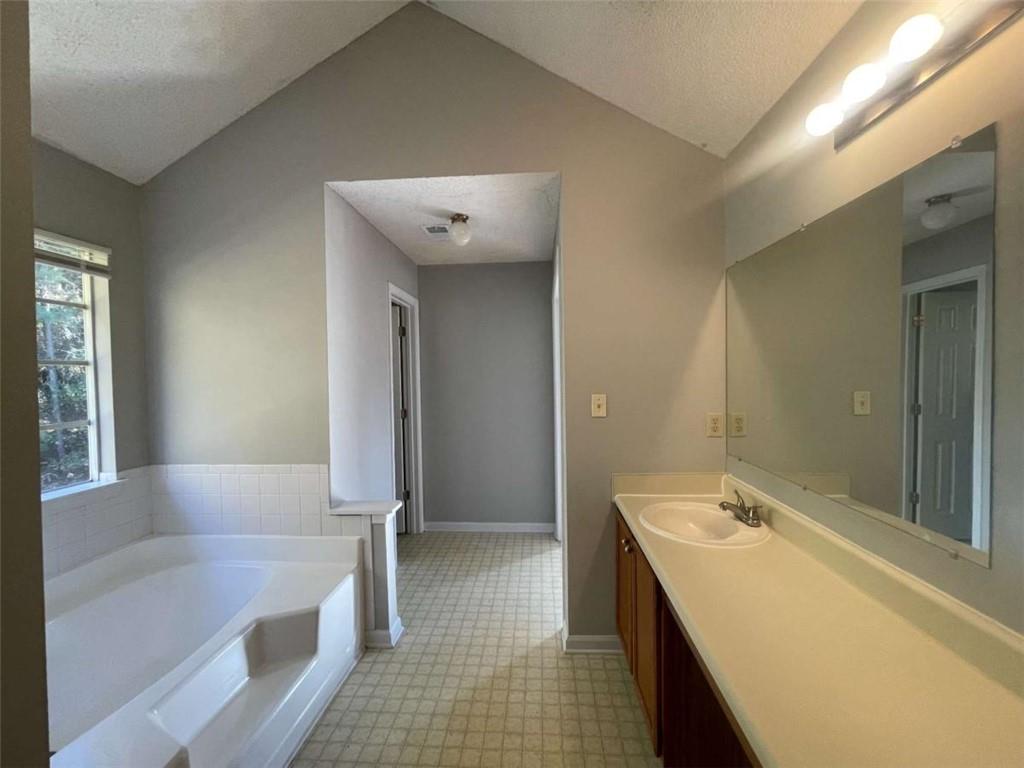 6387 Seths Way Lithonia, GA 30058 - Photo 29 of 44 a bathroom with a tub sink and mirror