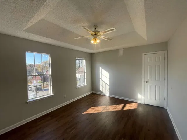 a view of an empty room with window and wooden floor