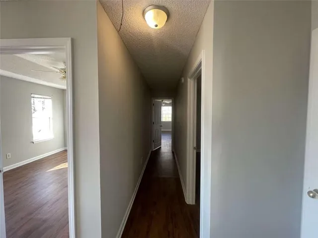 a view of a hallway with wooden floor and a window