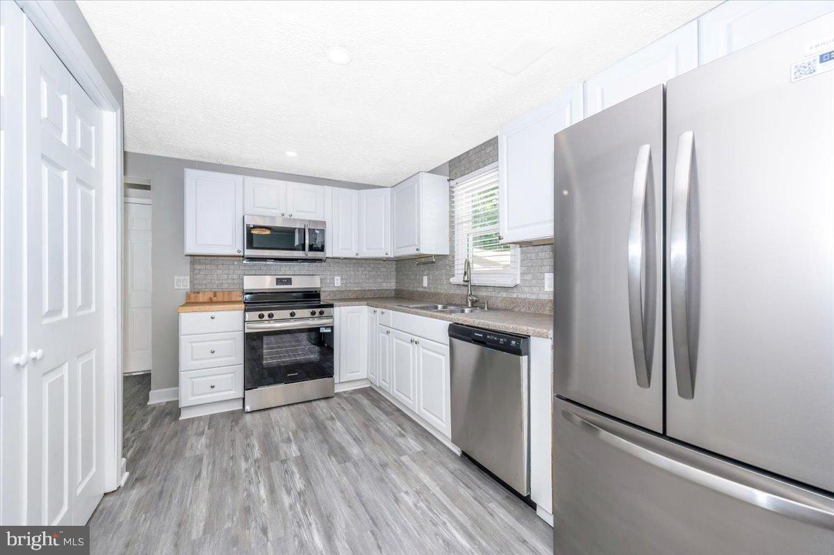 12284 Bandera Lane Lusby, MD 20657 - Photo 13 of 55 a kitchen with stainless steel appliances a refrigerator stove and sink