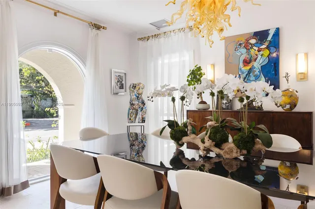 a view of a dining room with furniture one side kitchen view and wooden floor