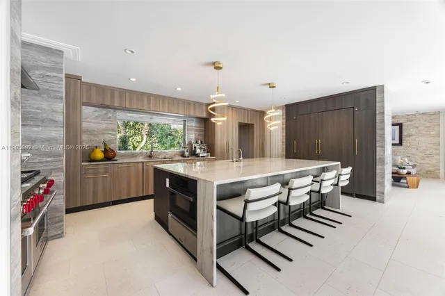 a kitchen with stainless steel appliances kitchen island granite countertop a stove a sink and a refrigerator