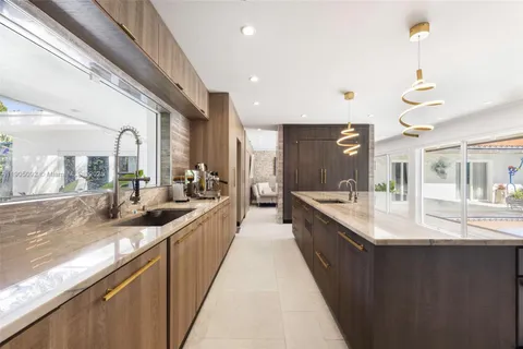 a large kitchen with stainless steel appliances lots of counter space and a sink