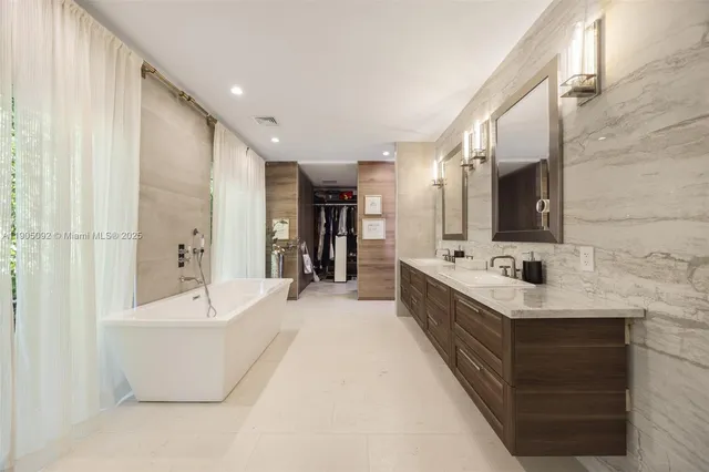 a spacious bathroom with a double vanity sink a mirror and a bathtub