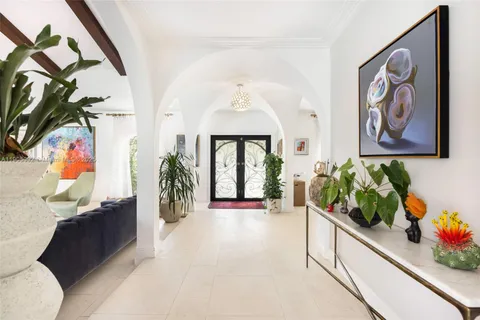 a hallway with painting and flowers