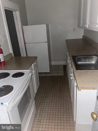 a kitchen with a sink a stove oven and refrigerator