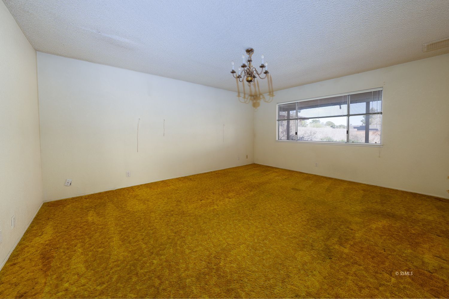 524 Scott Street Ridgecrest, CA 93555 - Photo 13 of 40 an empty room with a chandelier fan and windows