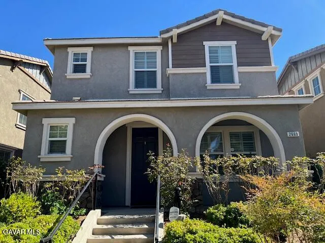 a front view of a house with plants