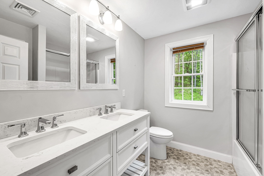 1310 North Brookfield Road Oakham, MA 01068 - Photo 28 of 30 a bathroom with a double vanity sink a toilet and a window