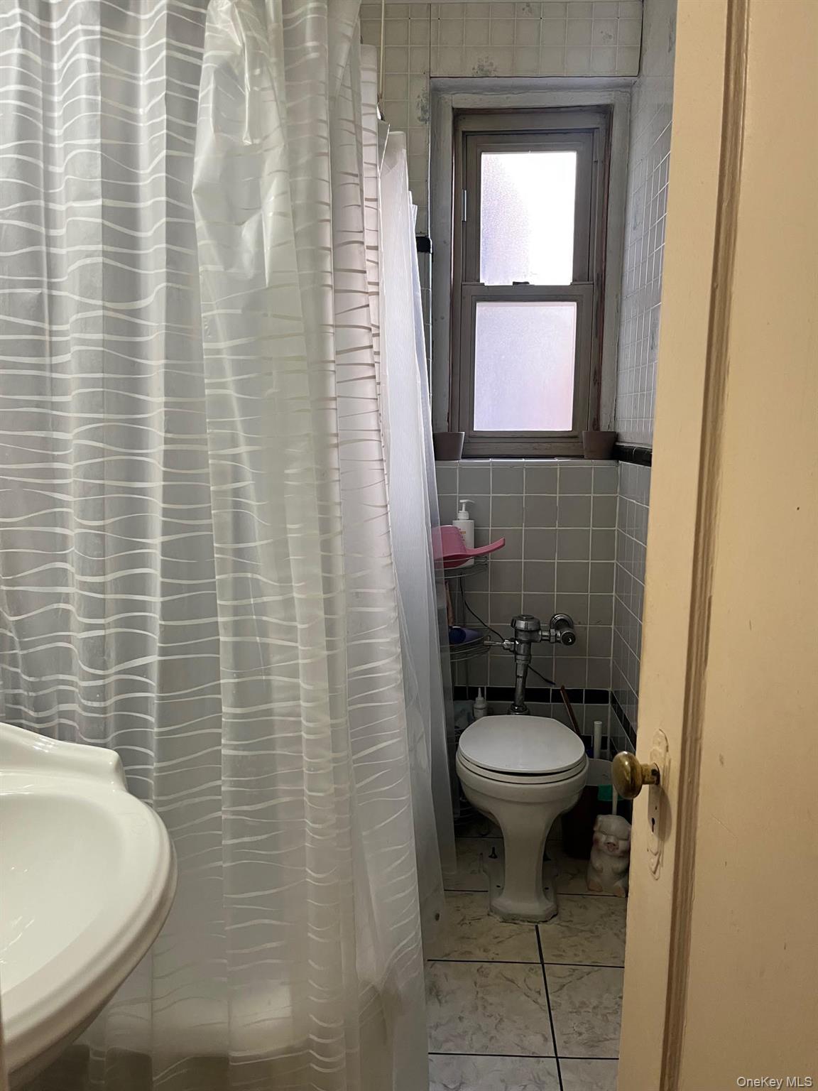 84-49 168th Street, Unit 2B Queens, NY 11432 - Photo 11 of 12 a bathroom with a sink a toilet and mirror