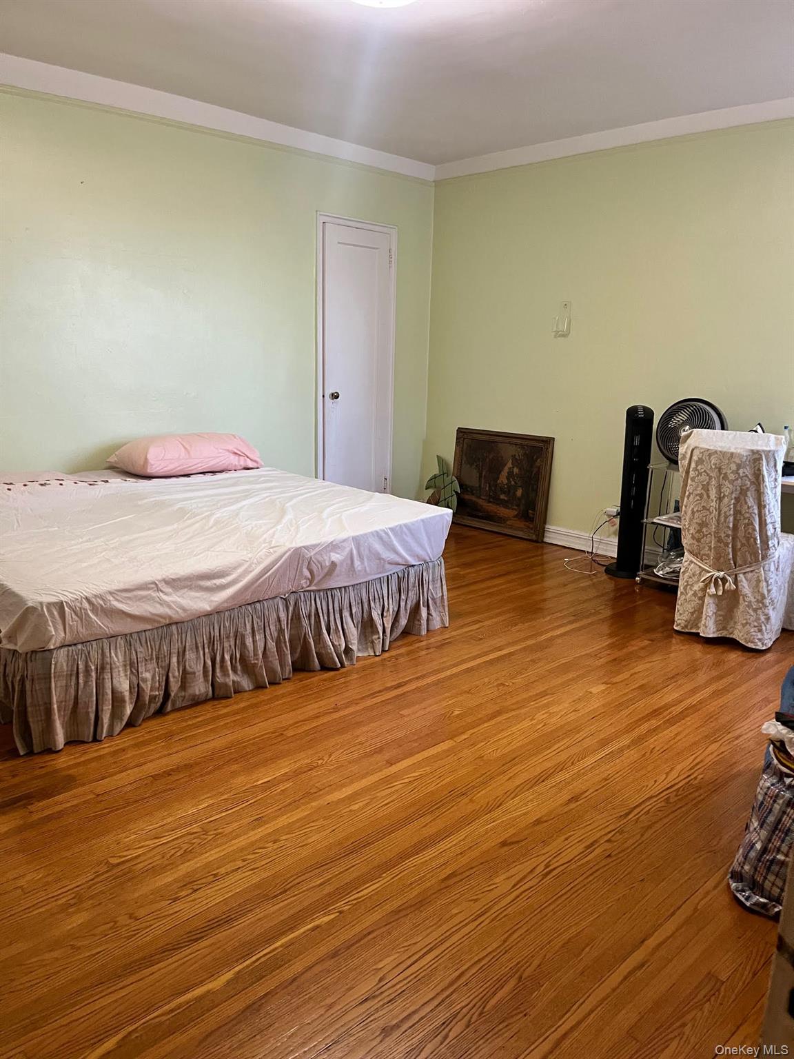 84-49 168th Street, Unit 2B Queens, NY 11432 - Photo 6 of 12 a bedroom with a bed and wooden floor