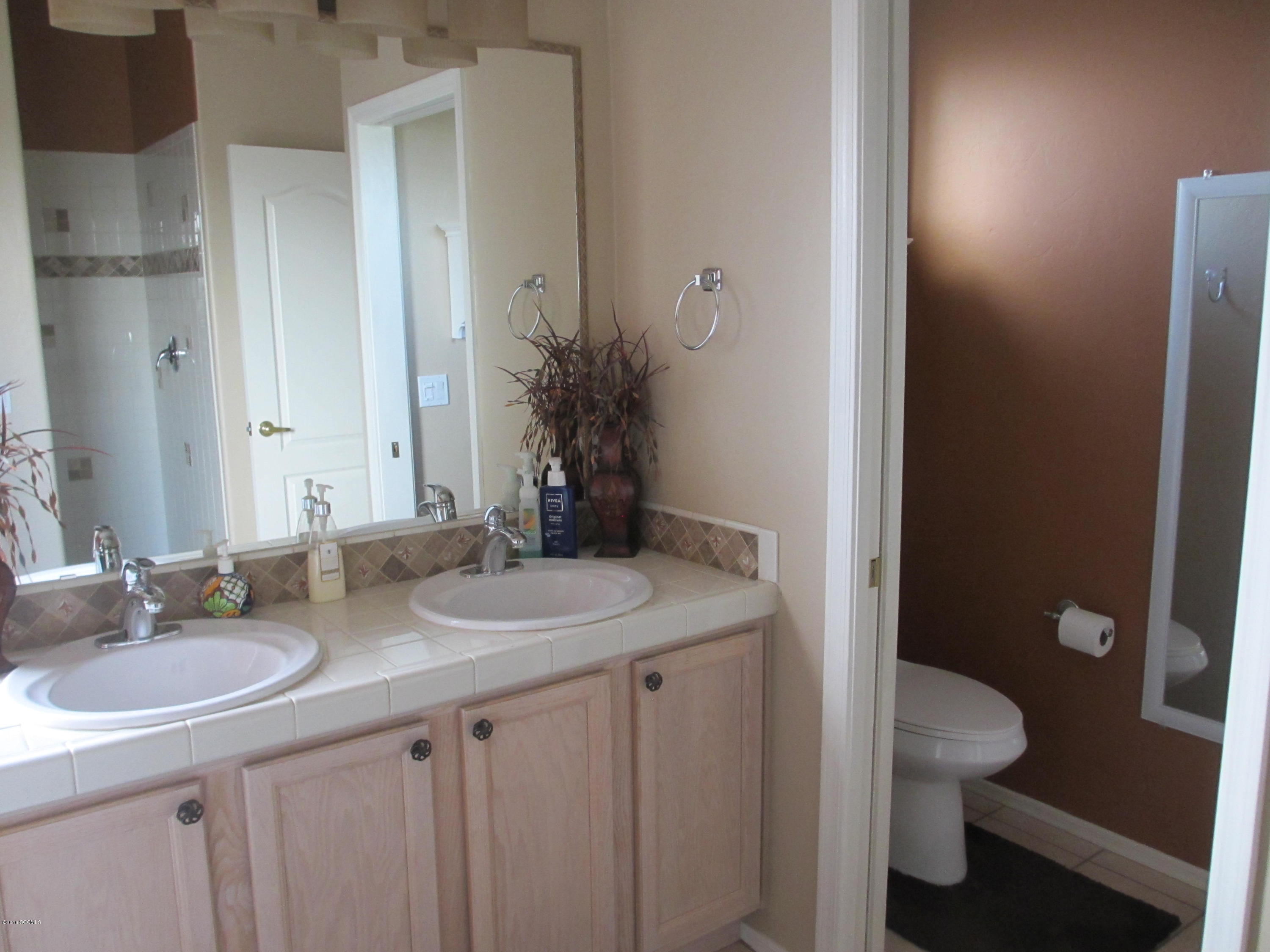 353 Via Bella Donna Rio Rico, AZ 85648 - Photo 10 of 44 a bathroom with a granite countertop sink a toilet and a mirror