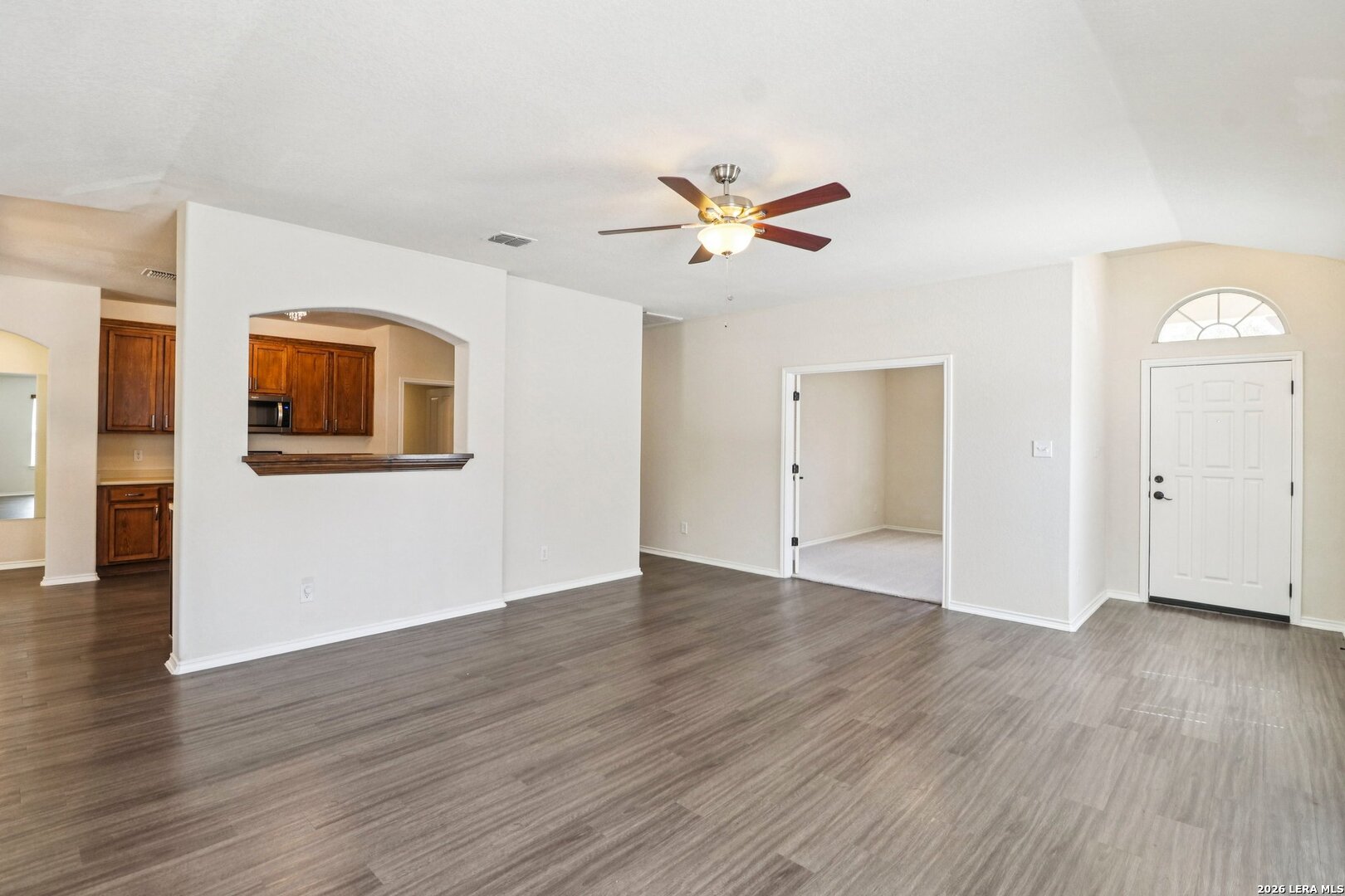 10723 Kobort Helotes, TX 78023 - Photo 11 of 36 a view of a big room with wooden floor and a ceiling fan