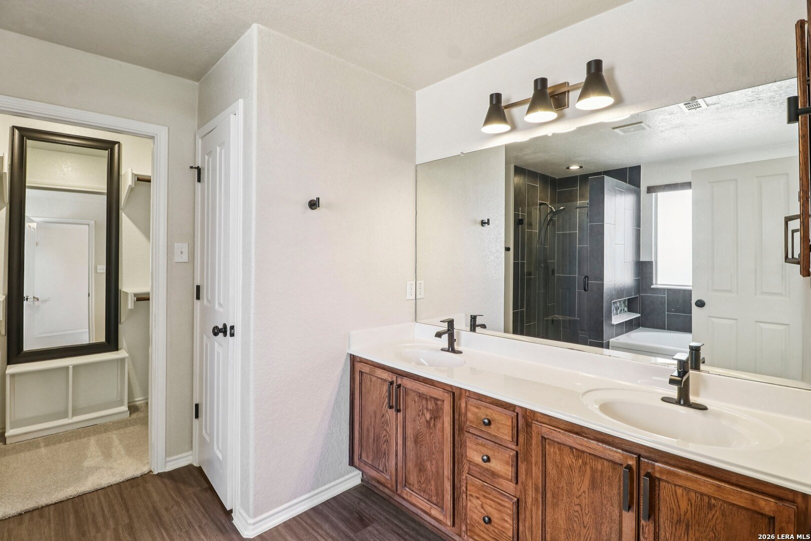 10723 Kobort Helotes, TX 78023 - Photo 24 of 36 a bathroom with double vanity sinks and a mirror