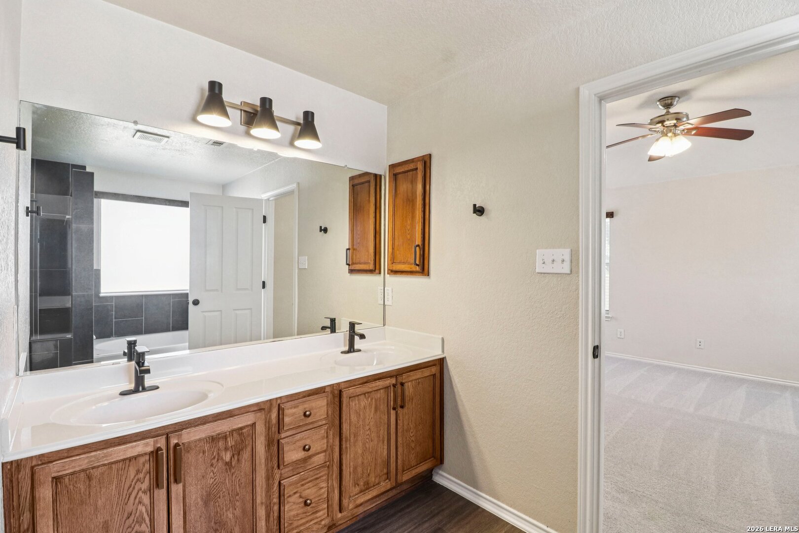 10723 Kobort Helotes, TX 78023 - Photo 27 of 36 a bathroom with a double vanity sink and mirror