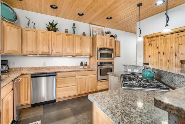 a kitchen with stainless steel appliances granite countertop a stove a sink and a refrigerator