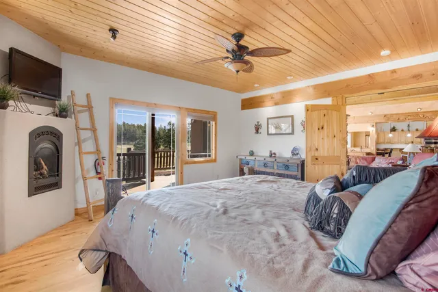 a spacious bedroom with a bed and a flat screen tv