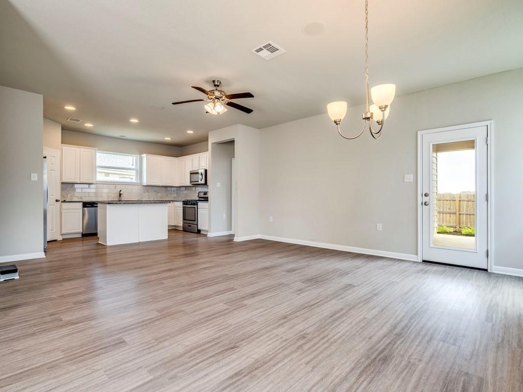 4210 Birdwatch Loop, Unit 2 Pflugerville, TX 78660 - Photo 30 of 31 An open floorplan seamlessly connects the well-appointed kitchen to the living area, creating an inviting space for gatherings.