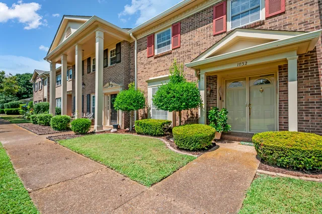 a front view of a house with garden and plants