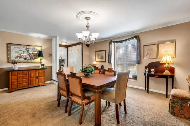 a view of a dining room with furniture and chandelier