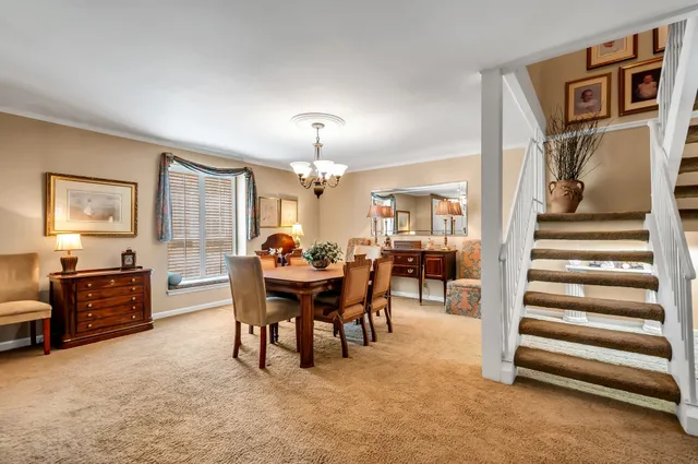 a view of a livingroom with furniture a dinning room and stairs