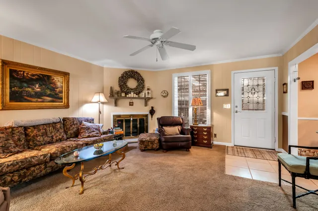 a living room with furniture a fireplace and a large window