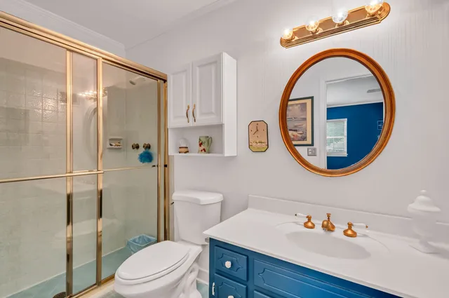 a bathroom with a sink a mirror a toilet and a shower