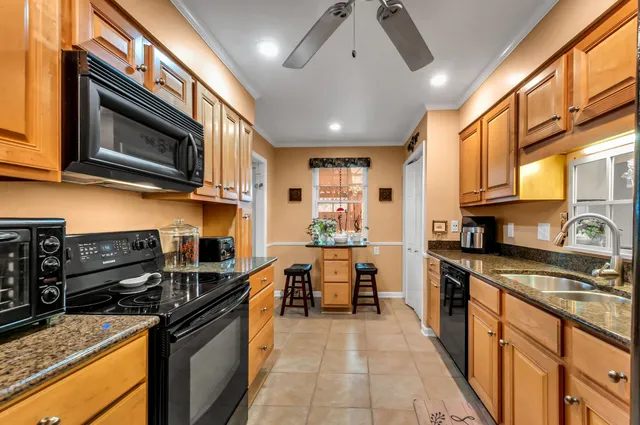 a kitchen with stainless steel appliances granite countertop a stove top oven a sink dishwasher and cabinets with wooden floor