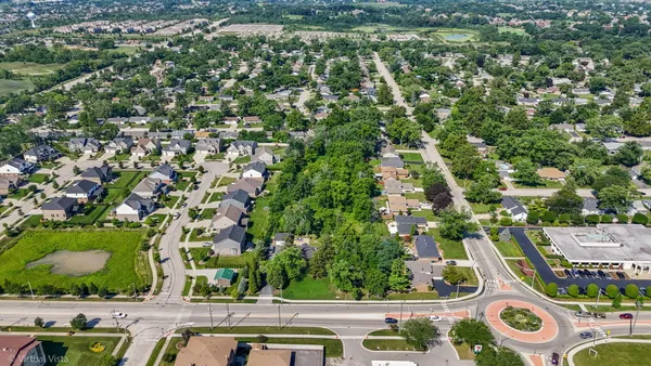an aerial view of residential houses with outdoor space and trees
