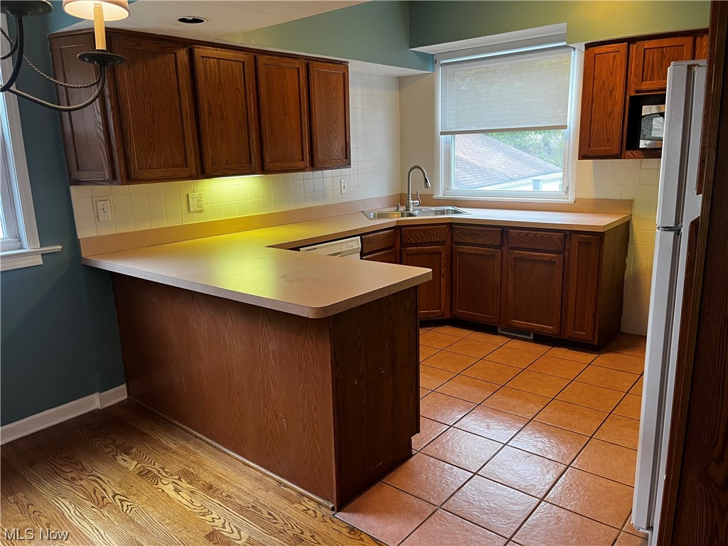 1610 Malasia Road Akron, OH 44305 - Photo 5 of 14 Kitchen featuring light hardwood / wood-style flooring, white fridge, tasteful backsplash, and sink