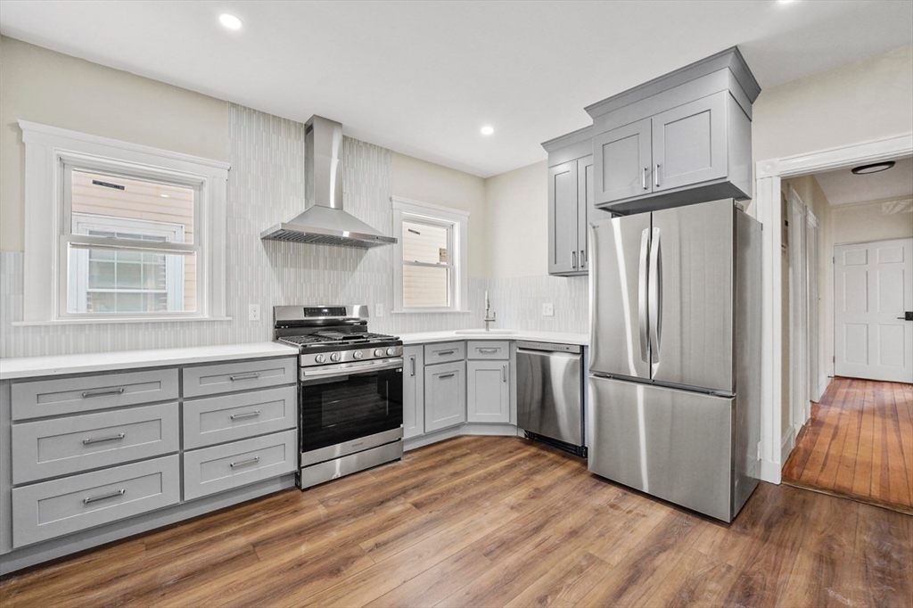 a kitchen with granite countertop a refrigerator and a stove top oven