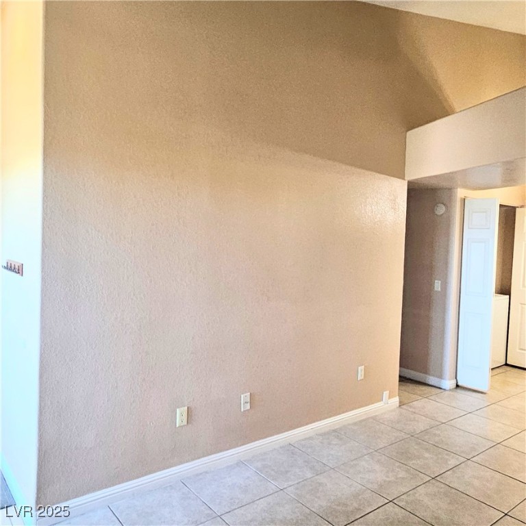 2120 Ramrod Avenue, Unit 1226 Henderson, NV 89014 - Photo 13 of 53 Spare room with light tile patterned floors and vaulted ceiling