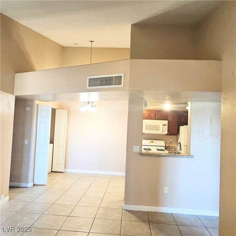 2120 Ramrod Avenue, Unit 1226 Henderson, NV 89014 - Photo 14 of 53 Kitchen with high vaulted ceiling, light tile patterned floors, and white appliances