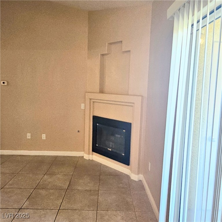 2120 Ramrod Avenue, Unit 1226 Henderson, NV 89014 - Photo 16 of 53 Unfurnished living room with a glass covered fireplace and tile patterned floors