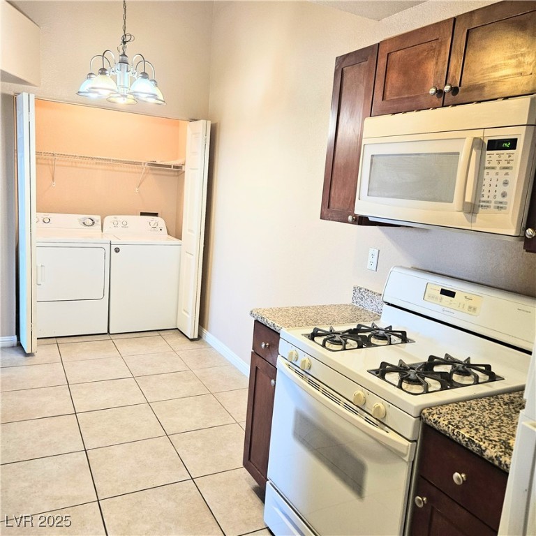 2120 Ramrod Avenue, Unit 1226 Henderson, NV 89014 - Photo 20 of 53 Kitchen featuring white appliances, independent washer and dryer, light tile patterned floors, dark brown cabinetry, and decorative light fixtures