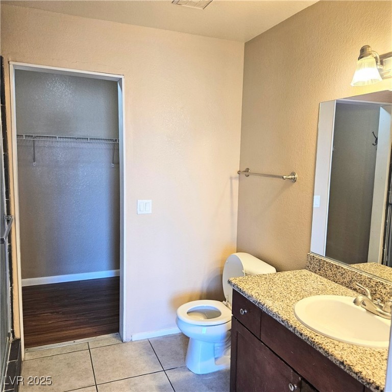 2120 Ramrod Avenue, Unit 1226 Henderson, NV 89014 - Photo 35 of 53 Full bathroom featuring vanity, tile patterned floors, a textured wall, and a walk in closet