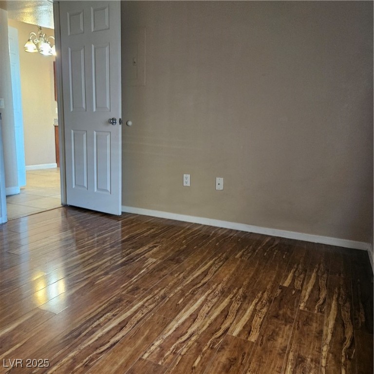 2120 Ramrod Avenue, Unit 1226 Henderson, NV 89014 - Photo 42 of 53 Empty room featuring wood finished floors and a chandelier