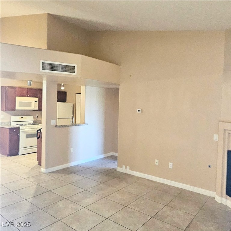 2120 Ramrod Avenue, Unit 1226 Henderson, NV 89014 - Photo 7 of 53 Unfurnished living room with light tile patterned flooring and lofted ceiling