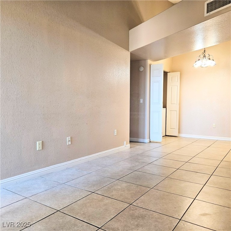 2120 Ramrod Avenue, Unit 1226 Henderson, NV 89014 - Photo 8 of 53 Spare room with light tile patterned flooring, a chandelier, and a towering ceiling