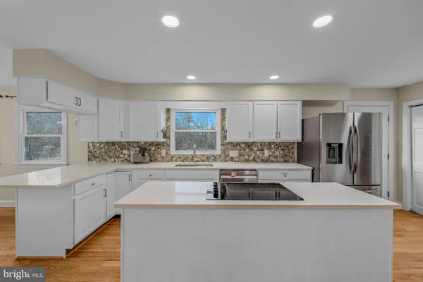a kitchen with a sink a counter top space stainless steel appliances and cabinets
