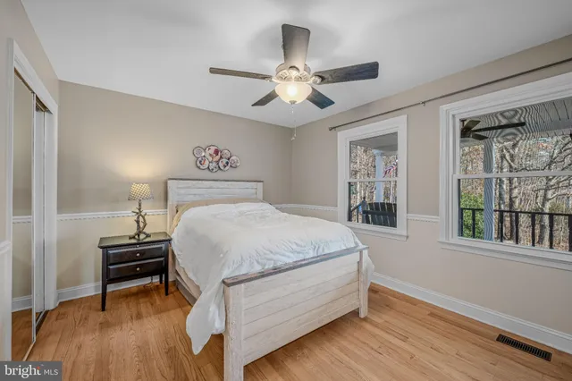 a bedroom with a bed and glass walk in closet