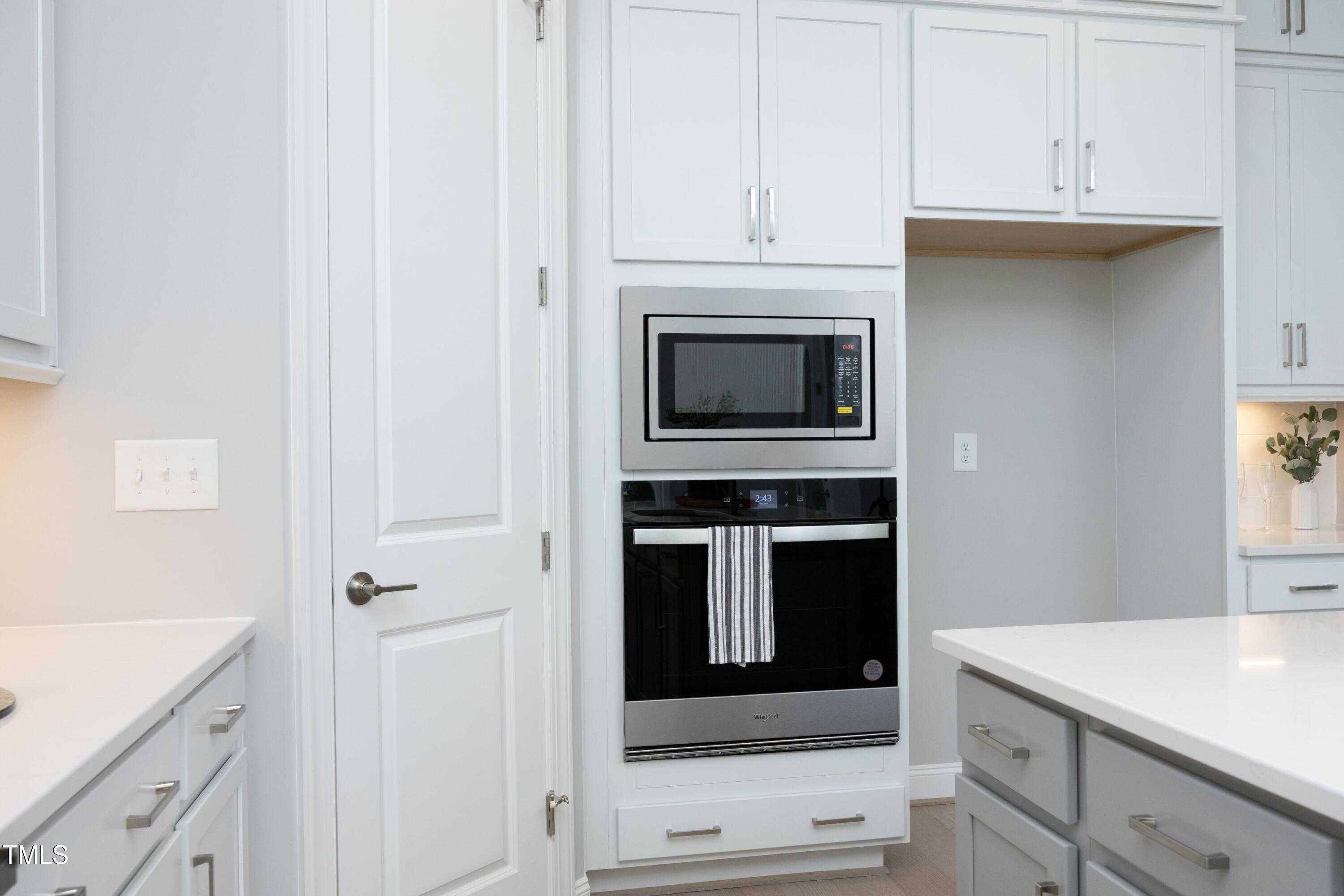 812 Willow Tower Court Rolesville, NC 27571 - Photo 16 of 43 a kitchen with white cabinets and stainless steel appliances
