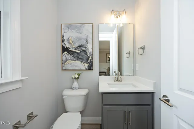 a bathroom with a toilet a sink and mirror