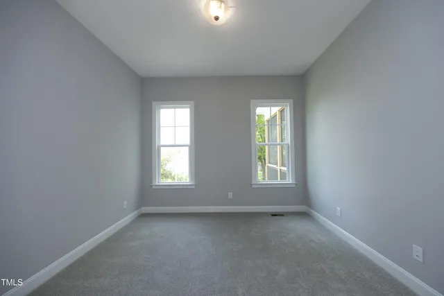 an empty room with closet and a bathroom