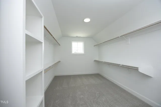an empty room with closet and windows