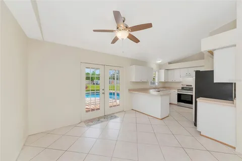 a large white kitchen with a stove a sink dishwasher and a refrigerator with white cabinets