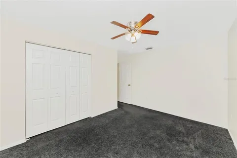 a view of a room with a ceiling fan and a window